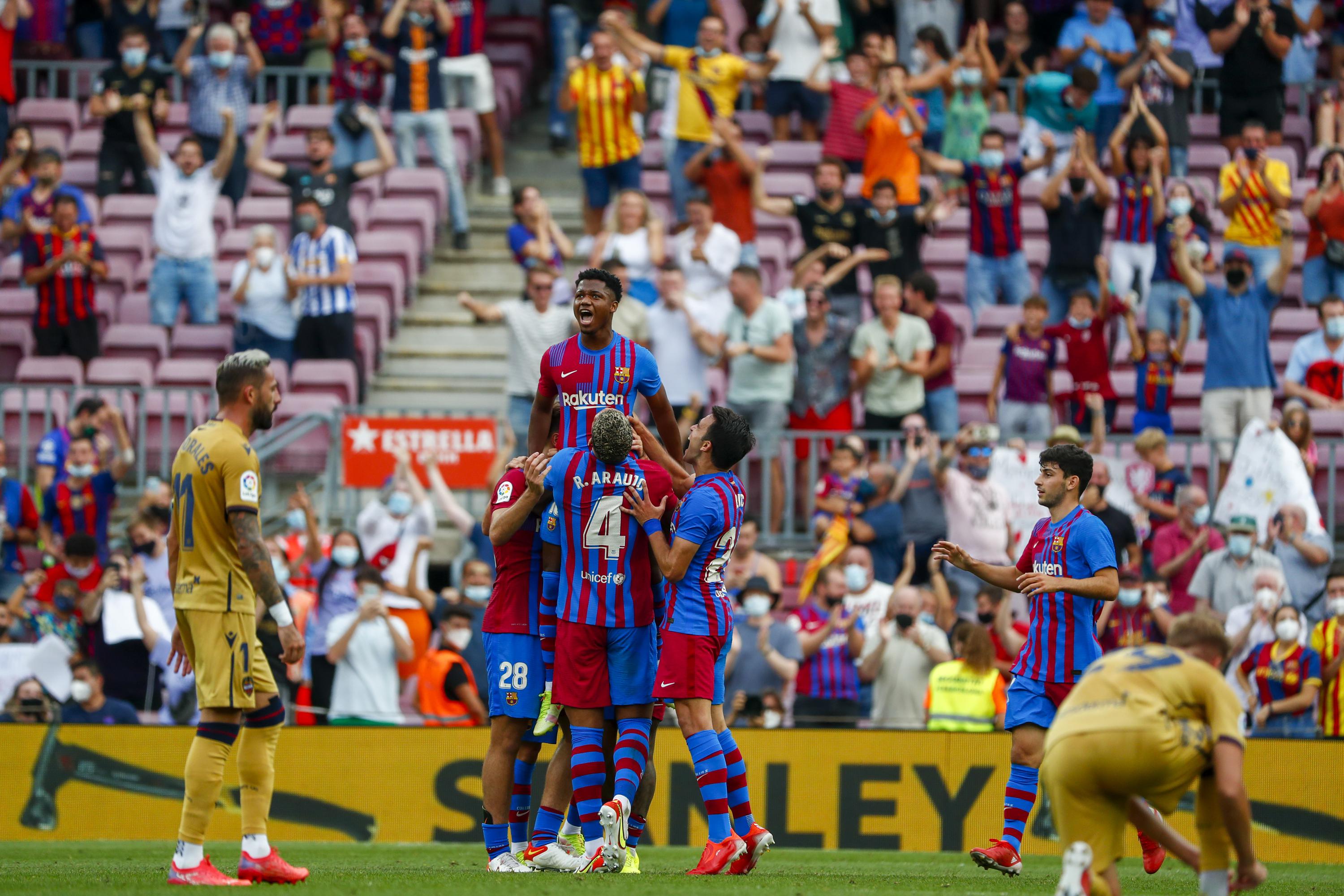  Barcelona players celebrate a goal against Levante despite the club's financial struggles.