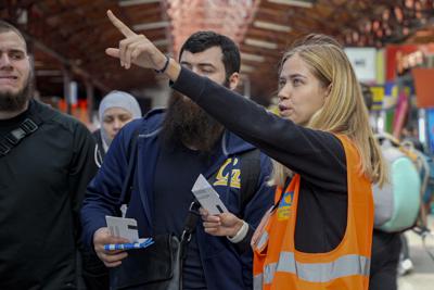 Anastasiia Haiduk, una refugiada ucraniana, trabajando como voluntaria en la estación de tren norte de Bucarest en Rumania, el sábado 23 de abril de 2022. (AP Foto/Chisato Tanaka)