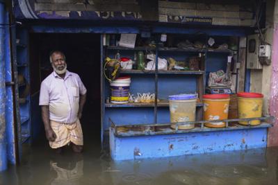 Un hombre de pie en la puerta de su tienda inundada en Sylhet, Bangladesh, el lunes 20 de junio de 2022. (AP Foto/Mahmud Hossain Opu)