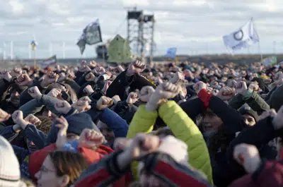 Varias personas protestan frente a una mina de carbón en Luetzerath, Alemania, el domingo 8 de enero de 2023. (Henning Kaiser/dpa vía AP)