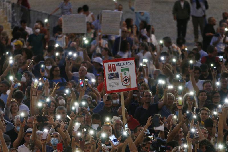 FILE - In this  Wednesday, July 28, 2021 file photo, people stage a protest against the COVID-19 vaccination pass in Rome. Shouts of “liberty” have echoed through Italian and French streets and squares as thousands show their opposition to plans to require vaccination cards to continue normal social activities, like dining indoors at restaurants, visiting museums or cheering home teams in stadiums. (Cecilia Fabiano/LaPresse via AP)