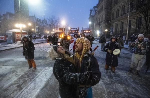 Los manifestantes bailan y se abrazan mientras suena una canción sobre los altavoces, durante una protesta en curso contra las medidas de COVID-19 que se ha convertido en una protesta antigubernamental más amplia, en Ottawa, Ontario, el jueves 17 de febrero de 2022. (Justin Tang/The Canadian Press vía AP)