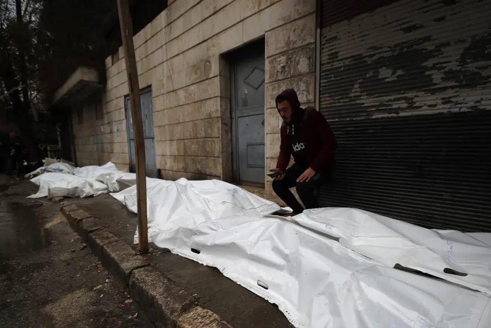 A man tries to identify the bodies of earthquake victims recovered outside a hospital, in Aleppo, Syria, Monday, Feb. 6, 2023. A powerful earthquake rocked wide swaths of Turkey and neighboring Syria on Monday, toppling hundreds of buildings and killing and injuring thousands of people. (AP Photo/Omar Sanadiki)