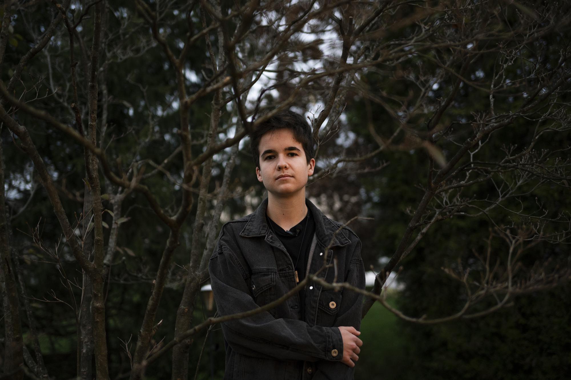 Leo Burchell stands for a portrait outside his family's home in Pennsylvania on Wednesday, Nov. 16, 2022. In late 2020, during the pandemic school closures, Leo Burchell started using different pronouns, trying on new clothes, cutting his hair short. The changes felt right. (AP Photo/Joe Lamberti)