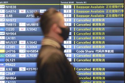 ARCHIVO _ Un hombre camina junto a una pizarra de información en el aeropuerto internacional Haneda en Tokio el 28 de diciembre del 2020. Japón anunció que comenzará a aflojar las restricciones a partir del 8 de noviembre del 2021 para viajeros plenamente vacunados, excluyendo turistas, en respuesta a pedidos de la comunidad de negocios luego de una declinación rápida de las infecciones con coronavirus.  (AP Foto / Koji Sasahara)