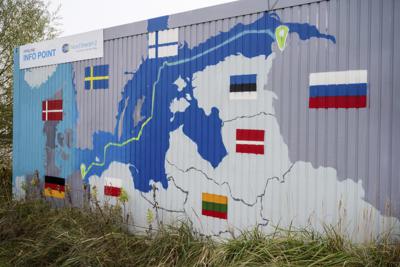 ARCHIVO - Un cartel con la leyenda "Nord Stream 2 Prometido. Confiable. Seguro" pende sobre un mapa pintado del gasoducto Nord Stream 2 de Rusia a Alemania enuna  estación de recepción de gas natural en Lubmin, Alemania, 16 de noviembre de 2021. (Stefan Sauer/dpa via AP)