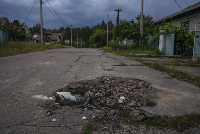 Parte de un proyectil de mortero, en una carretera en la localidad de Yahidne mientras la población civil reconstruye las viviendas destrozadas por los ataques rusos, en la región de Cherníhiv, en el norte de Ucrania, el 29 de junio de 2022. Meses después de la retirada de las tropas rusas de Yahidne, el pueblo ha regresado gradualmente a la vida. La población está reparando sus viviendas y el potente viento arrastra a veces el olor amargo de las cenizas. (AP Foto/Nariman El-Mofty)