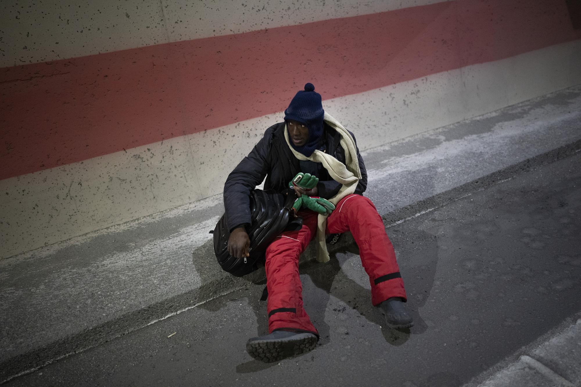 A migrant headed to France stops to rest as he walks from Cesana, Italy, along a tunnel leading to the Franch-Italian border, Saturday, Dec. 11, 2021. (AP Photo/Daniel Cole)
