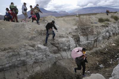 Migrantes de Venezuela cruzan a Chile desde la frontera con Bolivia cerca de Colchane, Chile, el jueves 9 de diciembre de 2021. (AP Foto/Matias Delacroix)