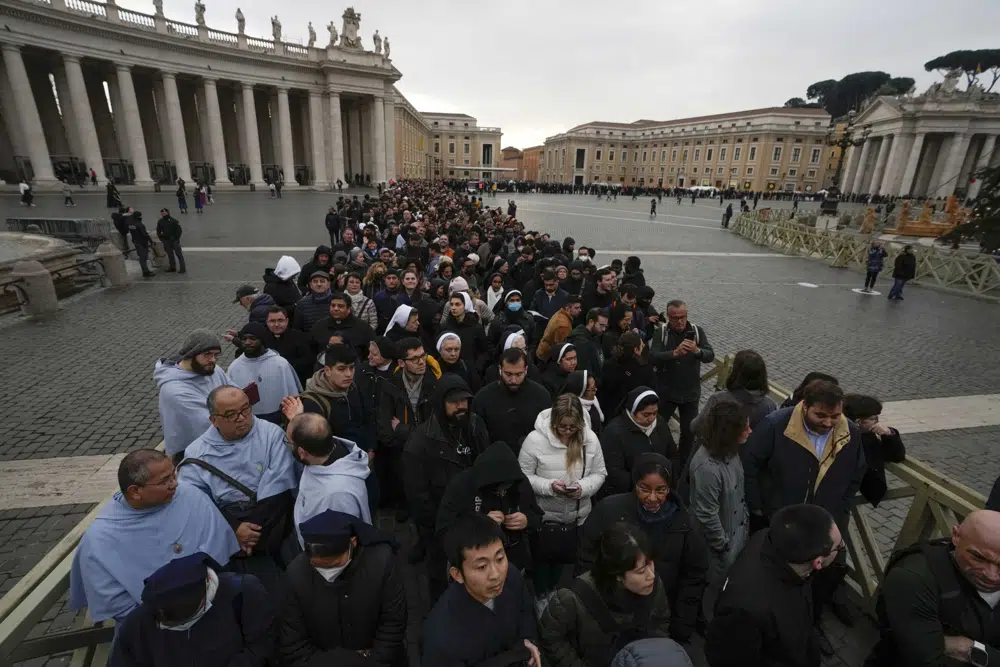 People wait in a line to enter Saint Peter's Basilica at the Vatican where late Pope Benedict 16 is being laid in state at The Vatican, Monday, Jan. 2, 2023. Benedict XVI, the German theologian who will be remembered as the first pope in 600 years to resign, has died, the Vatican announced Saturday. He was 95. (AP Photo/Alessandra Tarantino)