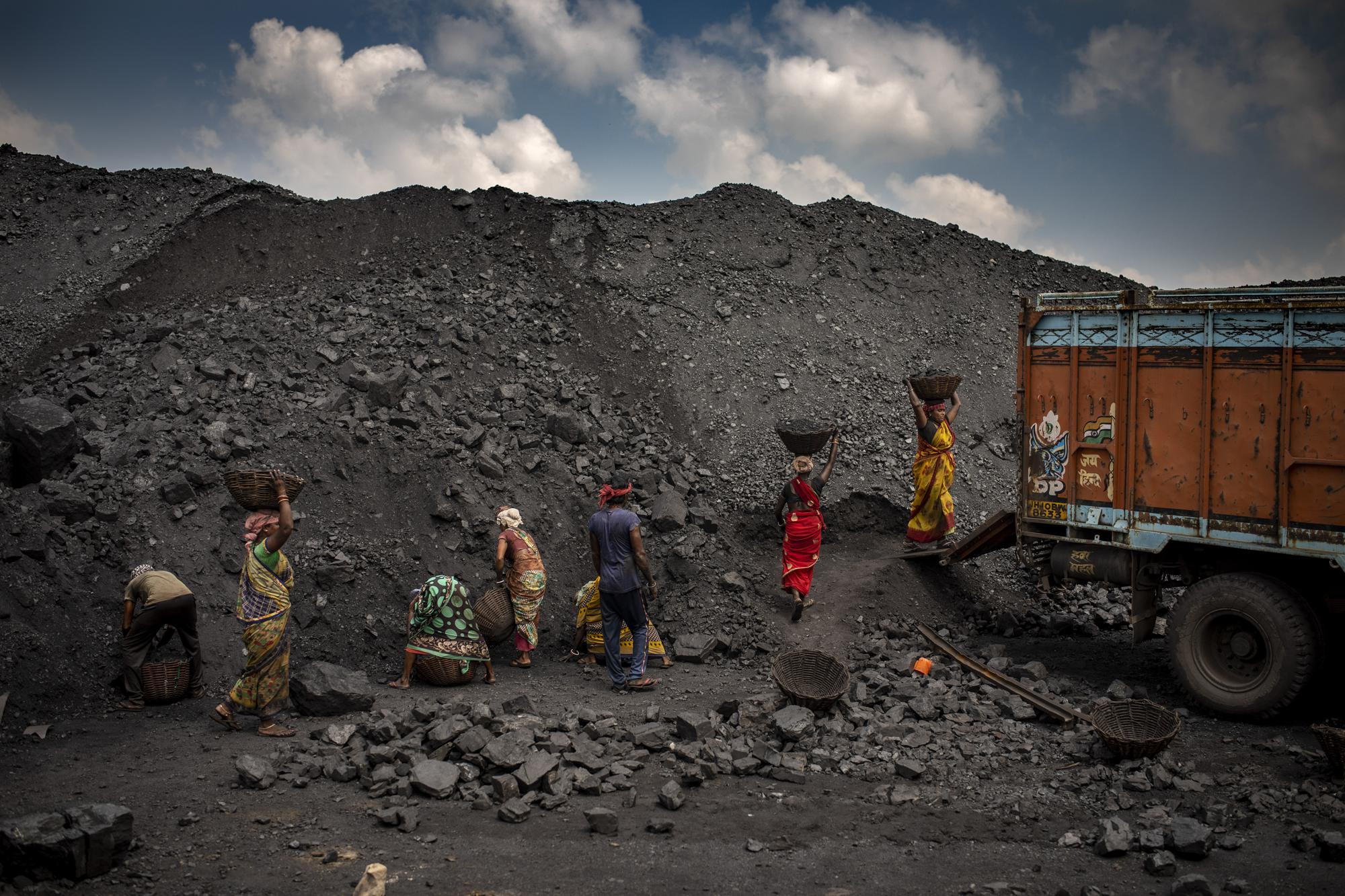 Indian laborers load coal into a truck in Dhanbad, an eastern Indian city in Jharkhand state, Friday, Sept. 24, 2021. A 2021 Indian government study found that Jharkhand state -- among the poorest in India and the state with the nation’s largest coal reserves -- is also the most vulnerable Indian state to climate change. Efforts to fight climate change are being held back in part because coal, the biggest single source of climate-changing gases, provides cheap electricity and supports millions of jobs. It's one of the dilemmas facing world leaders gathered in Glasgow, Scotland this week in an attempt to stave off the worst effects of climate change. (AP Photo/Altaf Qadri)