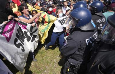 Una mujer habla con la policía durante una protesta de cara a la cumbre del Grupo de los Siete en Múnich el 25 de junio del 2022. (AP Foto/Matthias Schrader)