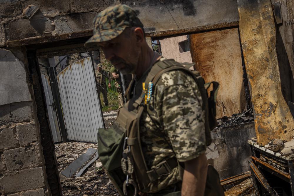 FILE - Commander of an artillery unit of the Ukrainian army, Mykhailo Strebizh, center, inside a destroyed house due to shelling in a village near the frontline in the Donetsk oblast region, eastern Ukraine, Thursday, June 2, 2022. (AP Photo/Bernat Armangue, File)