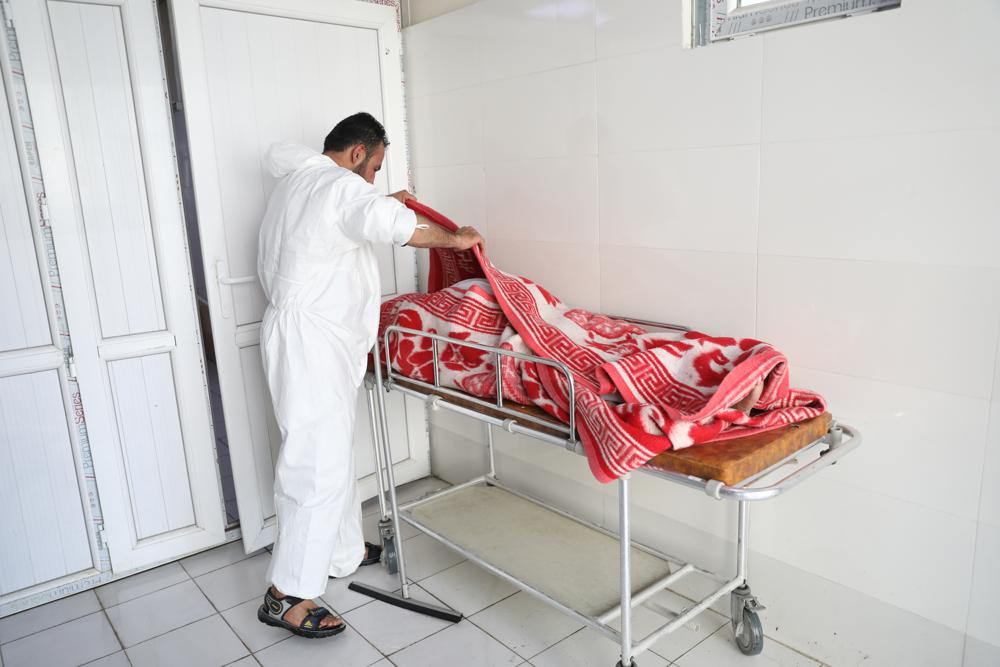 An Afghan health worker checks the body of a woman who died from COVID-19 at the Afghan-Japan Communicable Disease Hospital in Kabul, Afghanistan, Sunday, May 30, 2021. Afghanistan is battling a brutal third wave of COVID infections, while health officials plead for vaccines, expressing deep frustration at the inequities of the global vaccine distribution. Positive COVID cases jump from eight percent to 60 per cent in some parts of the country. (AP Photo/Rahmat Gul)