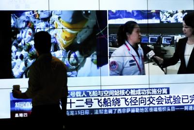 La silueta de un hombre frente a una pantalla que muestra un noticiero de la televisora CCTV con un reporte sobre el regreso de astronautas chinos a la Tierra, en un centro comercial en Beijing, el 16 de septiembre de 2021. (AP Foto/Andy Wong)
