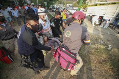 Rescatistas trasladan a una mujer herida en el accidente de un camión con migrantes en una autopista en Tuxtla Gutiérrez, en el estado de Chiapas, México, el 9 de diciembre de 2021. (AP Foto)