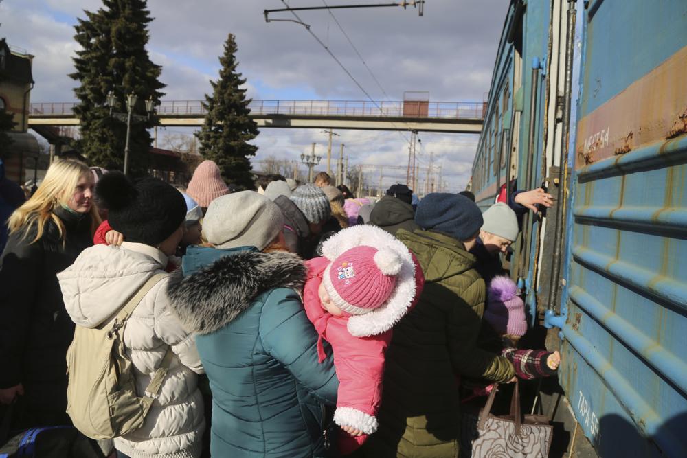 Los ciudadanos locales hacen fila para tomar un tren en la estación de tren para ser evacuados a Rusia, en Debaltseve, el territorio controlado por militantes prorrusos, en el este de Ucrania, el sábado 19 de febrero de 2022. El viernes, las autoridades separatistas en el este de Ucrania anunciaron una evacuación masiva de mujeres, niños y adultos mayores a la vecina Rusia.  Los movimientos han alimentado los temores occidentales de que Moscú pueda usar la última violencia en el este de Ucrania como pretexto para una invasión.  (Foto AP/Alexei Alexandrov)