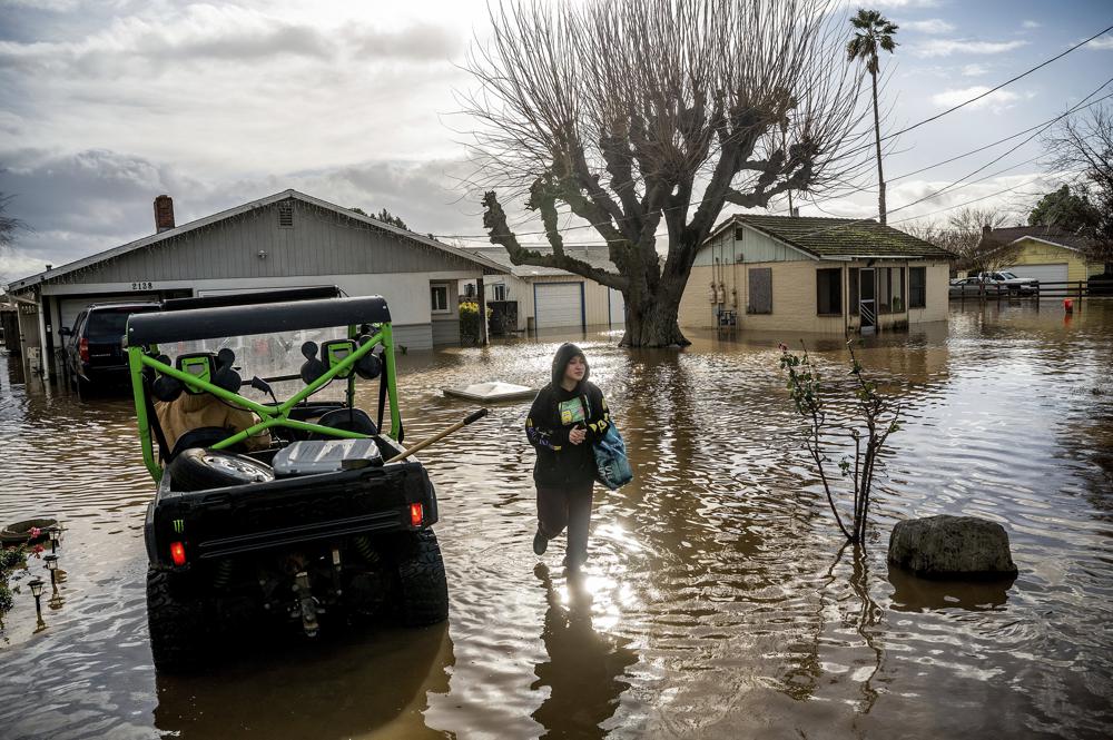 Brenda Ortega, de 15 años, recupera artículos de su casa inundada en Merced, California, el martes 10 de enero de 2023. Después de días de lluvia, Bear Creek se desbordó dejando docenas de casas y vehículos rodeados por las inundaciones. (Foto AP/Noah Berger)