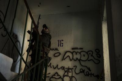 Un soldado ucraniano entra en un edificio cerca de una posición en el frente en Járkiv, Ucrania, el lunes 25 de abril de 2022. (AP Foto/Felipe Dana)