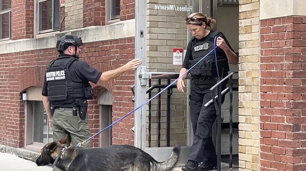 En esta fotografía tomada de un video, dos policías salen de un edificio en el campus de la Universidad Northeastern, el miércoles 14 de septiembre de 2022, en Boston. (AP Foto/Rodrique Ngowi)