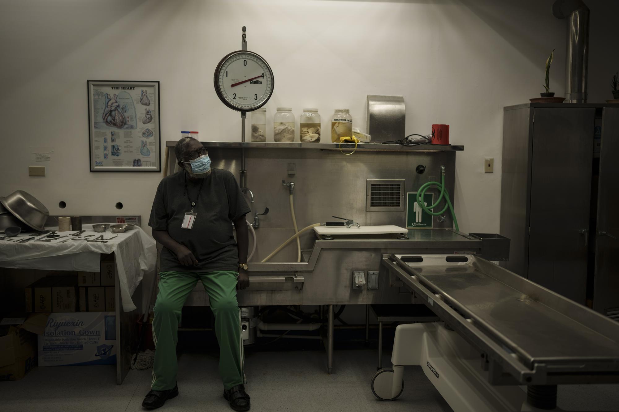 El técnico forense Thomas Philips, sentado en la morgue del hospital de Scarborough, en Tobago, Trinidad y Tobago, el 25 de enero de 2022. (AP Foto/Felipe Dana)