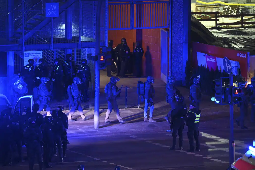 Armed police officers near the scene of a shooting in Hamburg, Germany on Thursday March 9, 2023 after one or more people opened fire in a church. The Hamburg city government says the shooting took place in the Gross Borstel district on Thursday evening. (Jonas Walzberg/dpa via AP)