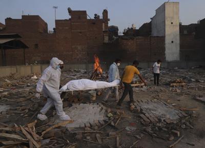 Fotografía de archivo del 11 de mayo de 2021 de familiares y voluntarios cargando el cuerpo de una víctima de COVID-19 para ser incinerada en Nueva Delhi, India. (AP Foto/Amit Sharma, archivo)