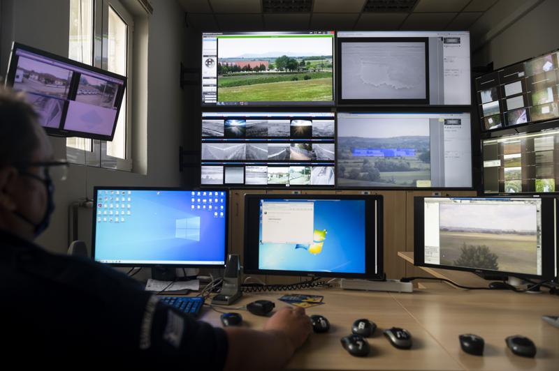 A police officer works inside the operation center at the village of Nea Vyssa near the Greek - Turkish border, Greece, Friday, May 21, 2021. An automated hi-tech surveillance network being built on the Greek-Turkish border aiming at detecting migrants early and deterring them from crossing, with river and land patrols using searchlights and long-range acoustic devices. (AP Photo/Giannis Papanikos)