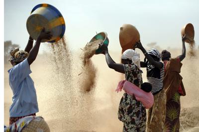 ARCHIVO- Mujeres malienses tamizan trigo en un campo cerca de Segou, en el centro de Malí, 22 de enero de 2013. En 2022, las familias de toda África están pagando alrededor de un 45% más por la harina de trigo, ya que la guerra de Rusia en Ucrania bloquea las exportaciones del Mar Negro. Algunos países como Somalia obtienen más del 90% de su trigo de Rusia y Ucrania. Eso está obligando a muchas personas a sustituir el trigo por otros granos. Pero las Naciones Unidas advierten que los aumentos de precios se avecinan, ya que muchas partes de África se enfrentan a la sequía y el hambre. (AP Photo/Jerome Delay, Archivo)