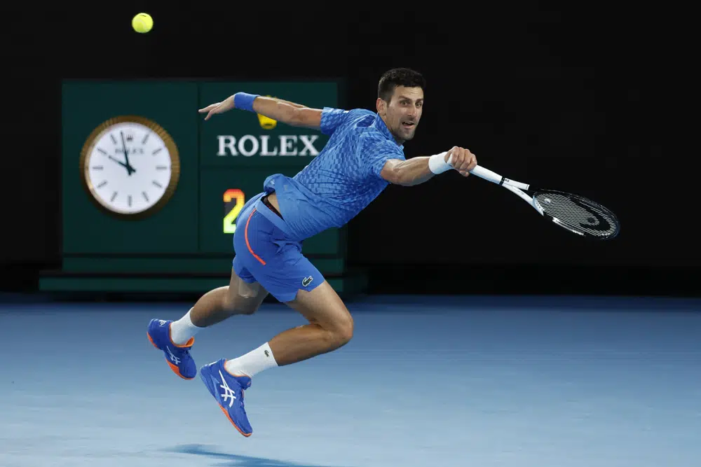 Novak Djokovic of Serbia plays a backhand to Stefanos Tsitsipas of Greece during the men's singles final at the Australian Open tennis championships in Melbourne, Australia, Sunday, Jan. 29, 2023. (AP Photo/Asanka Brendon Ratnayake)