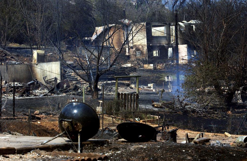 ARCHIVO - El humo se eleva de las cenizas de las casas quemadas por el incendio Coal Seam el 9 de junio de 2002, en Glenwood Springs, Colorado. Un área en las afueras de Denver donde el incendio forestal más destructivo en la historia de Colorado quemó 1,000 casas el mes pasado alberga numerosas minas de carbón abandonadas que las autoridades dicen que podría ser una causa potencial del incendio forestal impulsado por el viento.  La historia muestra que el carbón en descomposición ha provocado incendios antes, incluso cerca del mismo lugar al sur de Boulder en 2005, cuando un respiradero caliente de una mina en llamas provocó un incendio forestal que se extinguió rápidamente.  El incendio de una mina de carbón también provocó un incendio en la ciudad montañosa de Glenwood Springs, en Colorado, que quemó 29 casas en 2002. (Foto AP/Peter M. Fredin)