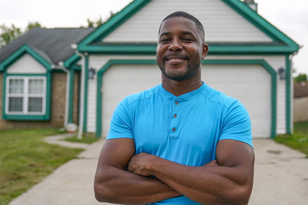 Johannes Favi, an immigrant from Benin, poses outside his home in Indianapolis, Monday, Aug. 16, 2021. An Illinois law which was supposed to end federal agreements to detain immigrants in county jails in the New Year has been delayed. Immigrant rights activists nationwide have celebrated the law as a step toward ending practices they consider inhumane and costly. Although some counties argue it may complicate things for immigrants who may be moved further from family and legal help. Favi, formerly detained in Kankakee, Ill., has been active in pushing for the end of detention of immigrants. (AP Photo/Michael Conroy)