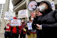 FILE - Teachers protest for stronger COVID-19 safety protocols outside Oakland Unified School District headquarters on Jan. 7, 2022, in Oakland, Calif. Officials across the U.S. are again weighing how and whether to impose mask mandates as COVID-19 infections soar and the American public grows weary of pandemic-related restrictions. Much of the debate centers around the nation’s schools, some of which closed due to infection-related staffing issues. (AP Photo/Noah Berger, File)