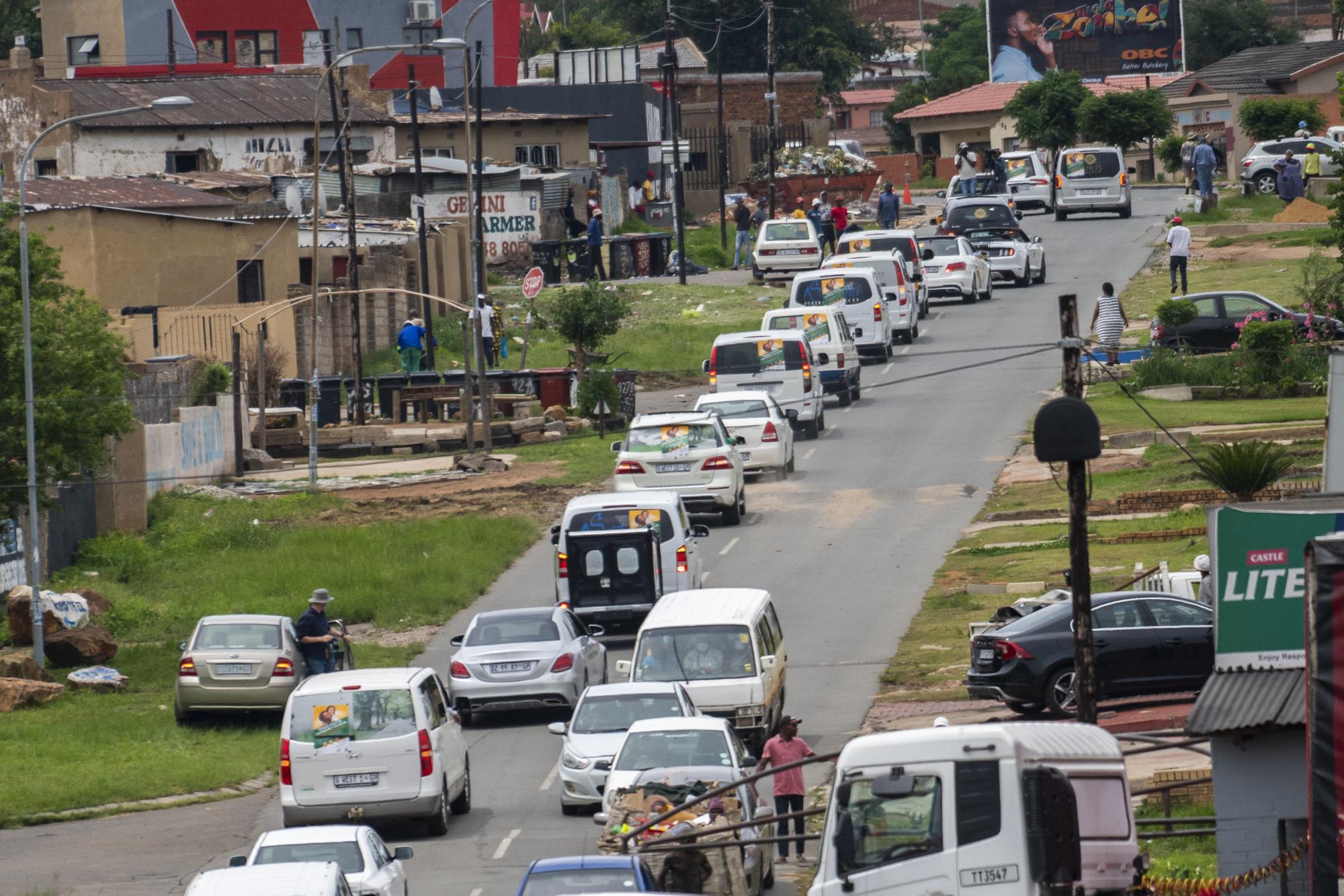 FILE - Funeral parlor hearses drive in a convoy through Soweto, South Africa, Tuesday Dec. 7, 2021. Over 40 hearses took part in what was a COVID-19 vaccine awareness campaign, with the catchy slogan: "We not in a hurry to see you!" From South African undertakers to ultra-Orthodox Israeli rabbis, an unconventional cadre of people has joined global efforts to increase COVID-19 vaccination rates. Launching campaigns that traditionally have been the realm of public health authorities, they’re opening church doors, going door to door, village to village, touting the benefits of vaccination, sometimes making shots available on the spot.  (AP Photo/Jerome Delay, File)