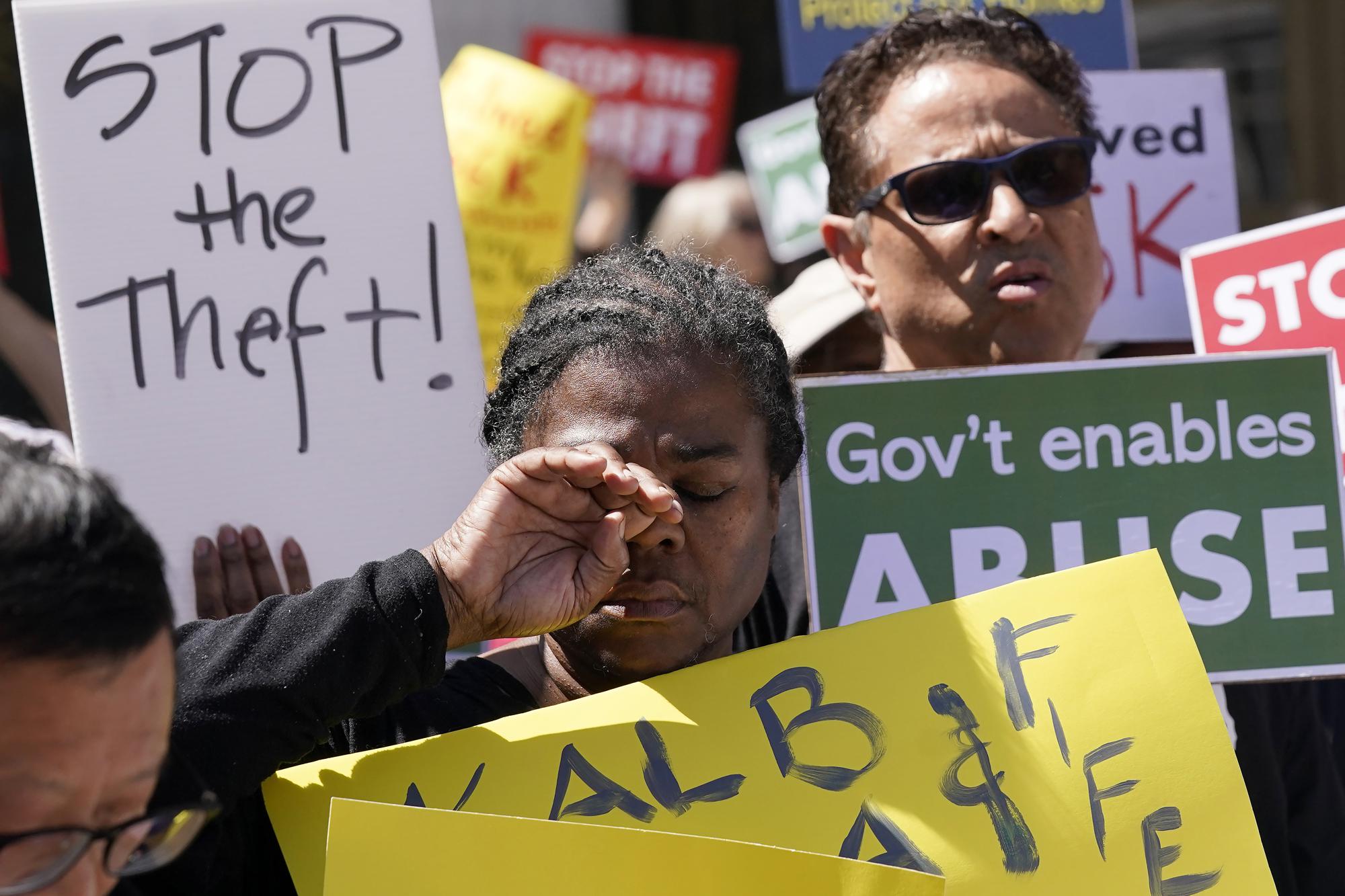 Michelle Hailey reacts while listening to speakers during a rally to end the eviction moratorium outside City Hall in Oakland, Calif., Tuesday, April 11, 2023. Some landlords have gone without rental income for more than three years after Oakland, California approved an eviction moratorium in March 2020. (AP Photo/Jeff Chiu)