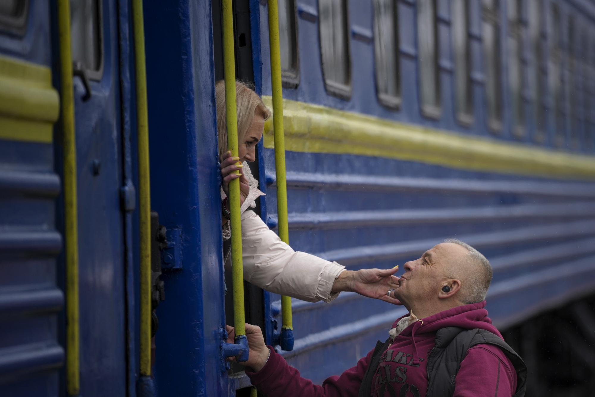 A woman bids a man goodbye after boarding a Lviv bound train, in Kyiv, Ukraine, Thursday, March 3, 2022. (AP Photo/Vadim Ghirda)