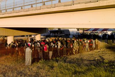 Migrantes, muchos procedentes de Haití, hacen fila el viernes 24 de septiembre de 2021 para subir a autobuses debajo del Puente Internacional de Del Rio, en Del Rio, Texas. (AP Foto/Julio Cortez)