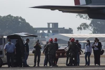 Un ataúd que contiene los restos de un migrante guatemalteco muerto en un accidente de camión en el sur de México, es transportado a un vehículo que esperaba en la pista del Aeropuerto Internacional La Aurora en la Ciudad de Guatemala, el jueves 30 de diciembre de 2021. (AP Foto/Oliver de Ros)