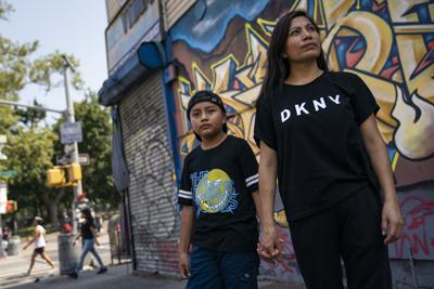 Mónica Muquinche, una ecuatoriana llegada recientemente a Estados Unidos tras cruzar la frontera sur estadounidense, posa junto a su hijo Sebastián el 26 de agosto del 2021 en Nueva York. (AP Photo/John Minchillo, File)