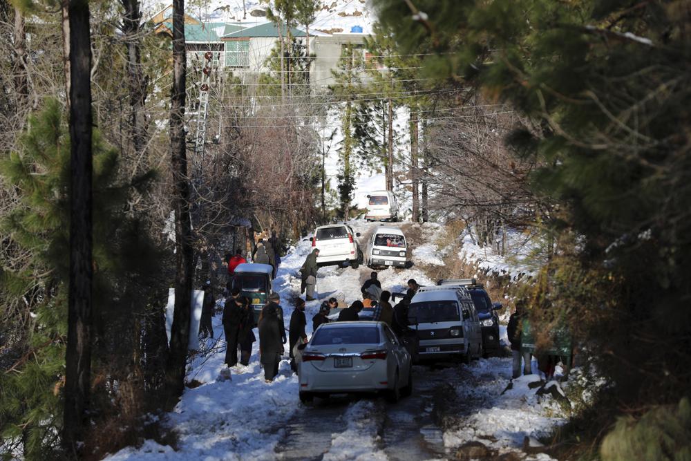 Vehicles are stranded on a snow-covered road in a heavy snowfall-hit area in Murree, some 28 miles (45 kilometers) north of the capital of Islamabad, Pakistan, Saturday, Jan. 8, 2022. Temperatures fell to minus 8 degrees Celsius (17.6 Fahrenheit) amid heavy snowfall at Pakistan's mountain resort town of Murree overnight, killing multiple people who were stuck in their vehicles, officials said Saturday. (AP Photo/Rahmat Gul)