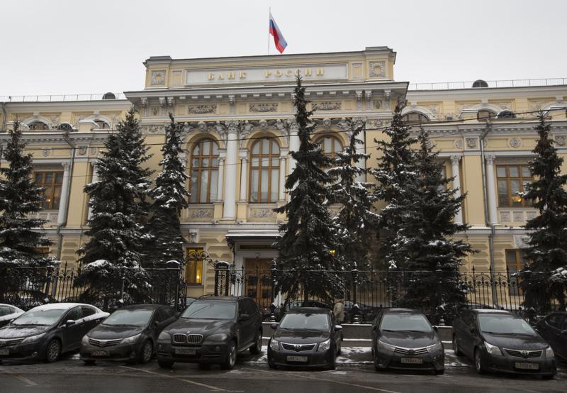 FILE - Cars are parked in front of Russia's Central Bank building in Moscow, Russia, Jan. 30, 2015. Prices for Russian credit default swaps — insurance contracts that protect an investor against a default — plunged sharply overnight after Moscow used its precious foreign currency reserves to make a last minute debt payment on Friday April 29, 2022. (AP Photo/Alexander Zemlianichenko, File)