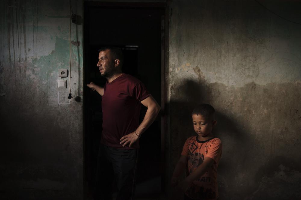 Jalal Nassir, de pie junto a su hijo en su casa, dañada en la reciente guerra de 11 días entre Israel y Hamas, el grupo que controla Gaza, en Beit Hanoun, en el norte de la Franja de Gaza, el sábado 12 de junio de 2021. Las guerras han causado daños por valor de más de 5.000 millones de dólares a los edificios e infraestructuras de Gaza. Casi 250.000 casas han quedado destruidas o dañadas.. (AP Foto/Felipe Dana)