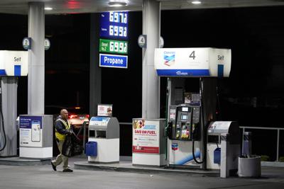 ARCHIVO - Un asistente pasa junto a una bomba en una estación que vende gasolina a más de $ 6 por galón, el lunes 7 de marzo de 2022, en Los Ángeles. Los gobernadores y legisladores estatales de todo Estados Unidos están luchando para aliviar los altos precios en la gasolinera. Están discutiendo formas de reducir o suspender los impuestos a la gasolina, pero dar ese paso no ha resultado fácil, ya que gran parte de ese dinero se destina a la reparación de carreteras y puentes. (AP Foto/Marcio José Sánchez, Archivo)