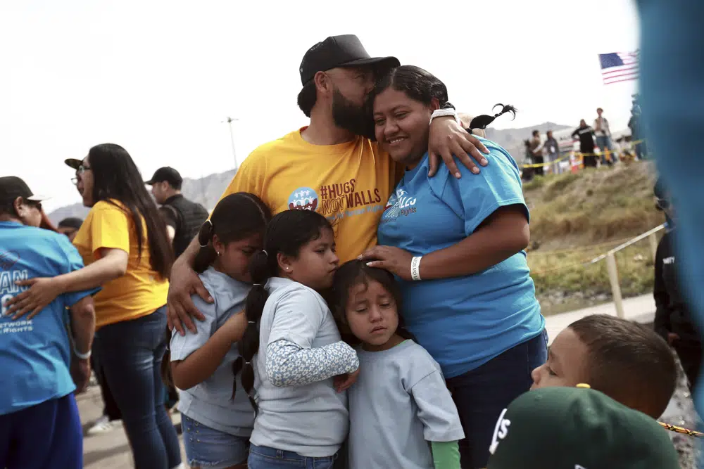 People living in the U.S. embrace with people living in Mexico during the 10th annual "Hugs not Walls" event, on a stretch of the Rio Grande, in Ciudad Juarez, Mexico, Saturday, May 6, 2023. The brief family reunions are part of a campaign sponsored by the Border Network for Human Rights, an immigration rights group. (AP Photo/Christian Chavez)