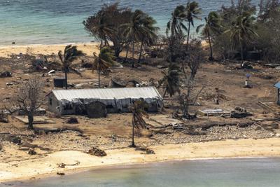 ARCHIVO - En esta imagen proporcionada por la Fuerza Australiana de Defensa, restos de un edificio dañado y árboles derribados en la isla de Atata en Tonga el 28 de enero de 2022, tras la erupción de un volcán submarino y un tsunami. (POIS Christopher Szumlanski/Fuerza Australiana de Defensa via AP, Archivo)