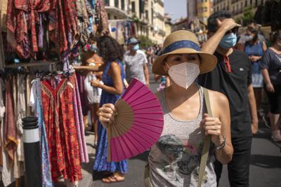 Una mujer se refresca con un abanico en Madrid, España, el domingo 15 de agosto de 2021. (AP Foto/Andrea Comas)