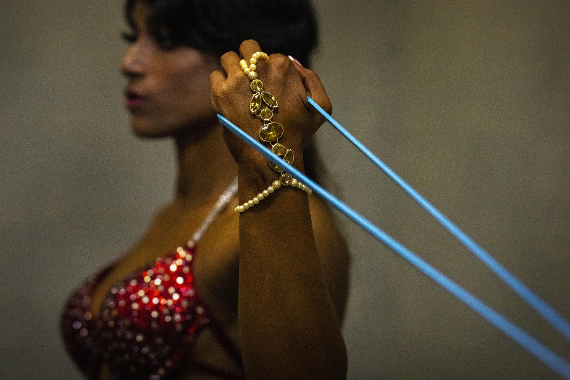 Una fisicoculturista se prepara entre bastidores para participar en el primer campeonato nacional de fisicoculturismo Miss Saraighat en Gauhati, estado nororiental de Assam, India, el sábado 2 de abril de 2022. (Foto AP/Anupam Nath)