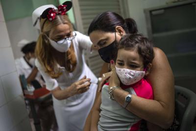 Una madre sostiene a su hija a la que se le inyecta una dosis de la vacuna Soberana-02 para el COVID-19 en La Habana, Cuba, el jueves 16 de septiembre de 2021. (AP Foto/Ramón Espinosa)