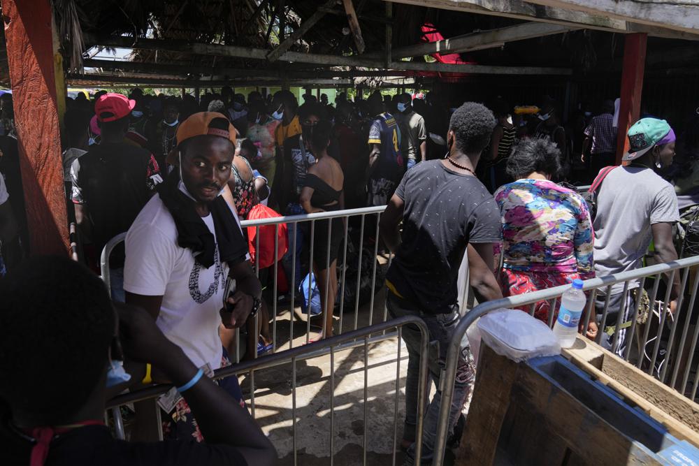 Migrantes, en su mayoría de Haití, hacen fila para abordar un autobús que los trasladará a otro refugio en su viaje por Panamá, tratando de llegar a Estados Unidos, en Lajas Blancas, provincia de Darién, Panamá, el viernes 1 de octubre de 2021. (Foto AP/Arnulfo Franco)