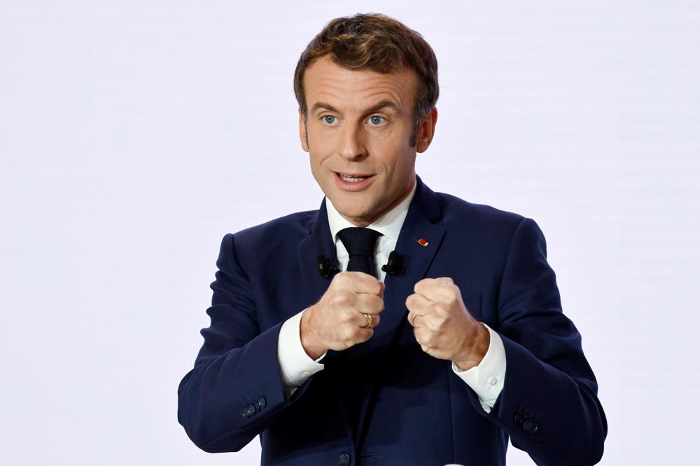 French President Emmanuel Macron gestures as he delivers a speech during a press conference on France assuming EU presidency, Thursday, Dec. 9, 2021. French President Emmanuel Macron presents the priorities for France's upcoming presidency of the European Union, a tenure that overlaps with the country's presidential election and could put Macron in a tricky position if he campaigns for reelection. (Ludovic Marin/Pool Photo via AP)